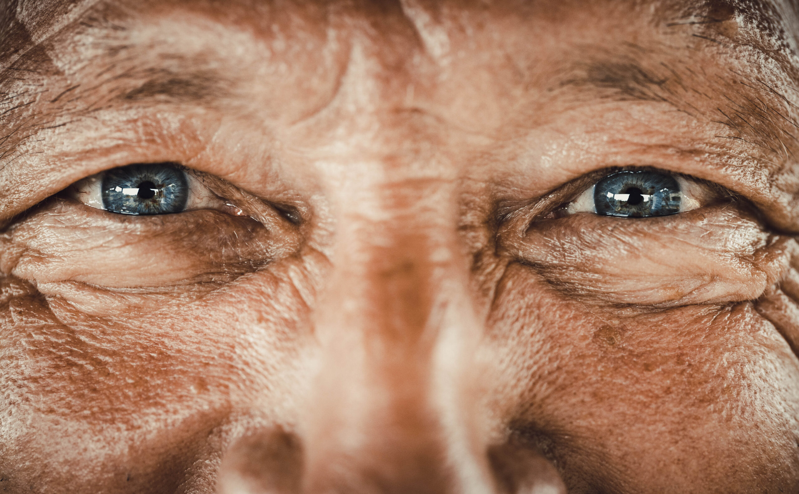 Close up of senior man's blue eyes looking at camera.